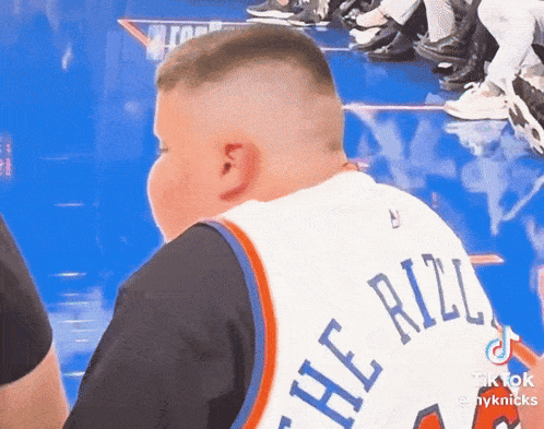 a young boy wearing a jersey that says the rizzly on it