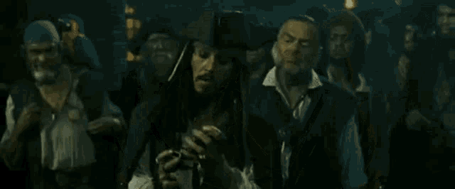 a man in a pirate costume is standing in front of a group of people
