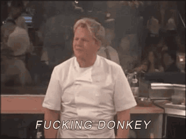 a man in a white shirt is standing in front of a crowd and says fucking donkey