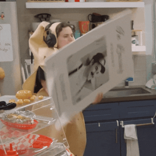 a woman in a banana costume is holding a piece of paper with a picture of a man on it