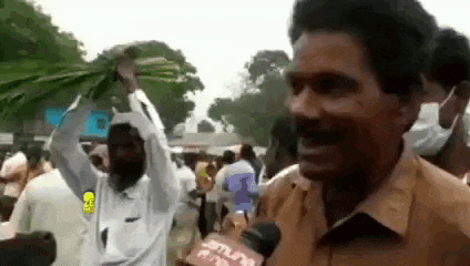 a man is talking into a microphone while holding a bunch of vegetables in his hand .