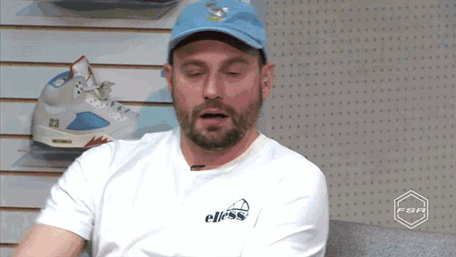 a man wearing a blue hat and a white shirt with the word elless on the front