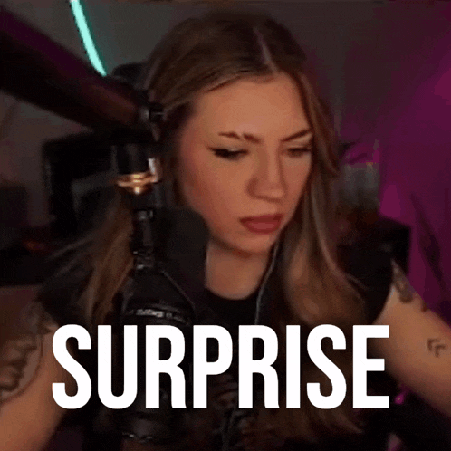 a woman sitting in front of a microphone with the word surprise written on the screen