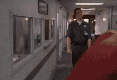a man is standing in a hallway with his fist up in the air .