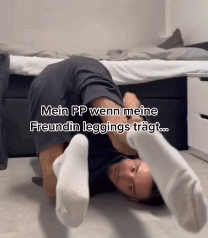 a man is laying on the floor wearing white socks and shorts .