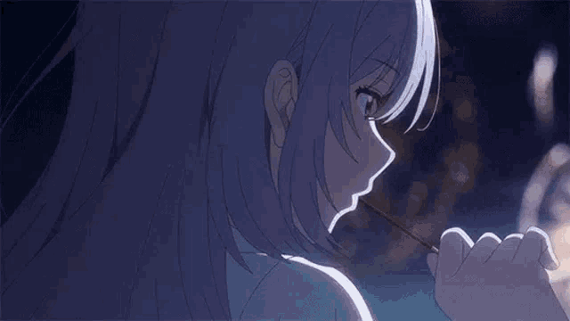 a girl with long gray hair is eating a candy bar .