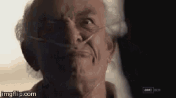an older man wearing an oxygen mask is looking at the camera .
