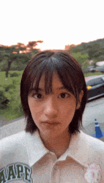 a young girl with short hair is wearing a white shirt with a rabbit on it .