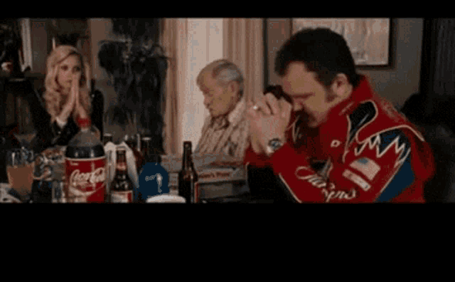 a man in a tuxedo t-shirt prays in front of a coca cola bottle