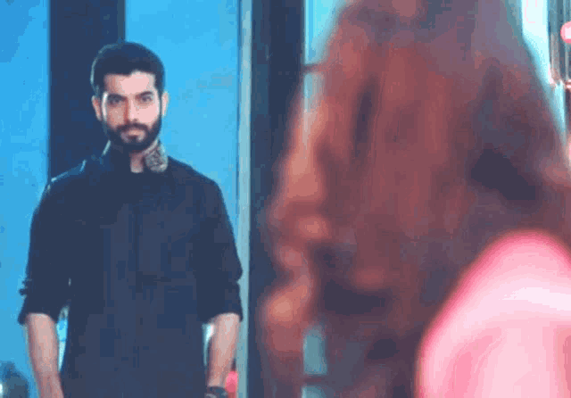 a man and a woman are standing next to each other in a room .