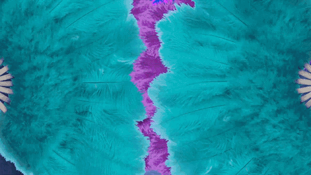 a purple sports car is surrounded by blue feathers in a dark room