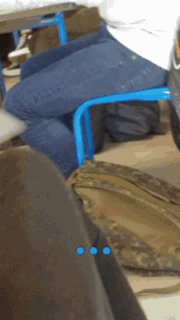 a person is sitting on a blue chair with their legs crossed