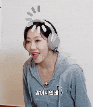 a woman wearing headphones and a hoodie with the letter t on the front