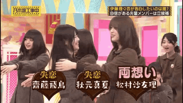 a group of girls hugging each other on a stage with chinese writing on the bottom