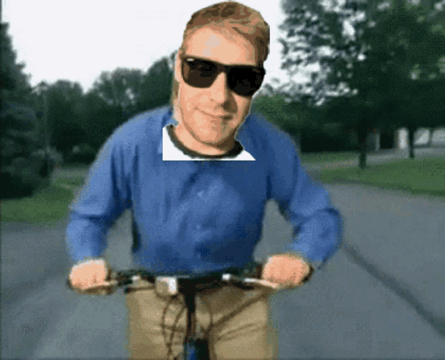 a man wearing sunglasses and a blue shirt is riding a bicycle