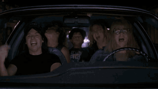a group of people in a car one of whom is wearing a shirt that says metallica