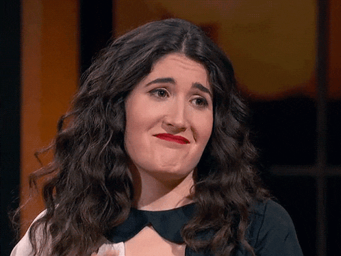 a woman with long curly hair making a face