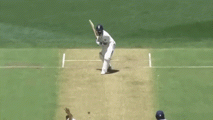 a cricket player is swinging a bat at another player who is standing on the wicket