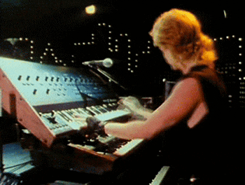 a woman is playing a keyboard with a microphone behind her