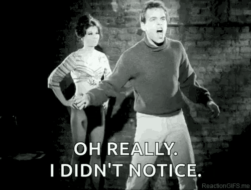 a man and a woman are standing next to each other in front of a brick wall and the man is screaming .