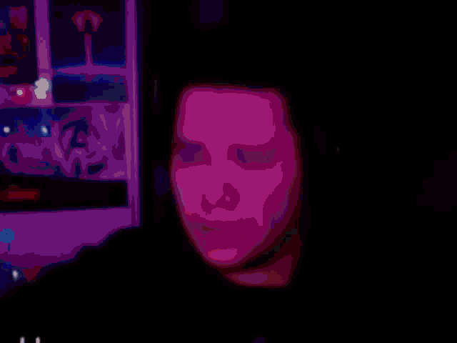 a blurry picture of a man 's face in front of a computer monitor