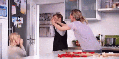 a woman is giving a high five to another woman in a kitchen