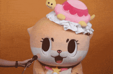 a stuffed animal with a cake on its head is being interviewed with a microphone