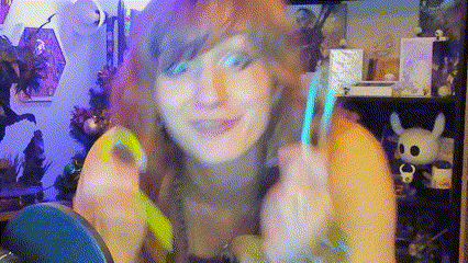 a woman with long hair is holding a green object in her hands .