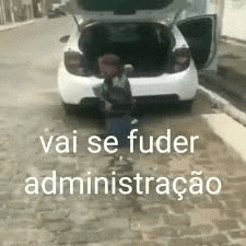 a child is standing next to a car with the trunk open .