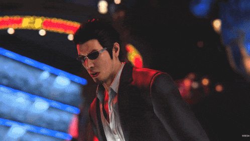 a man in a suit and sunglasses stands in front of a neon sign that says ' tokyo ' on it