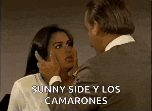 a man is touching a woman 's face and the words sunny side y los camarones are on the screen