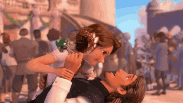 a man is holding a girl in his arms in front of a crowd of people