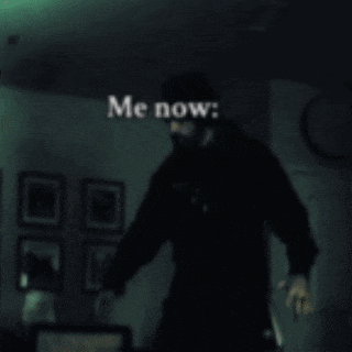 a blurry picture of a man standing in a dark room with the words " me now " written above him