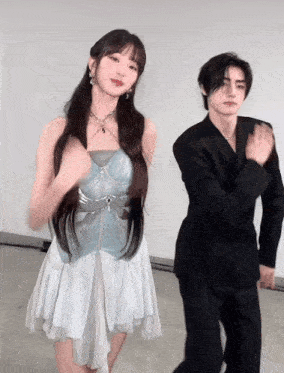 a man and a woman are dancing together and the woman is wearing a white dress