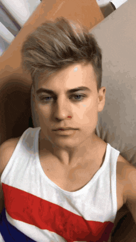a young man wearing a red white and blue tank top has a bloody nose