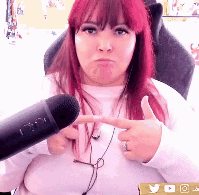 a woman with red hair is giving a thumbs up sign