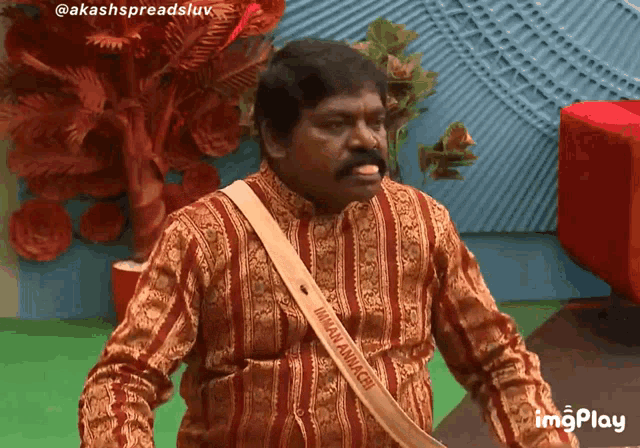 a man with a sash around his neck that says ' akash spreadsluv ' on it