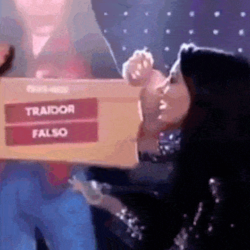 a woman is holding a box that says traidor and falso