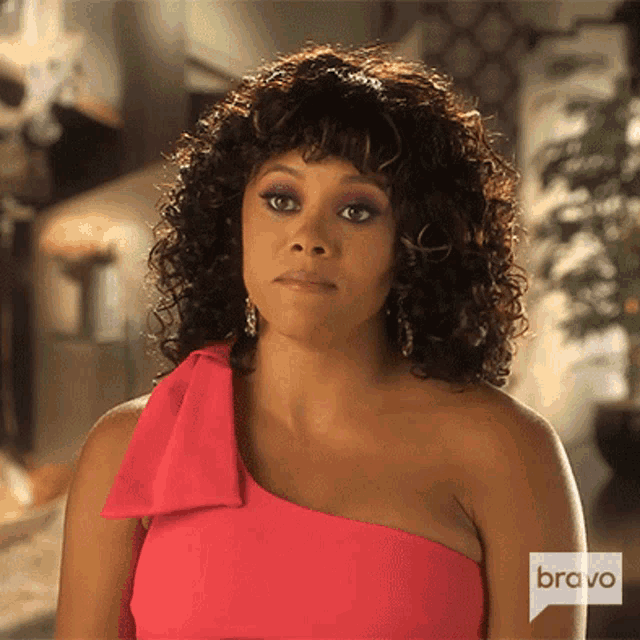 a woman in a pink dress with a bravo logo on the shoulder