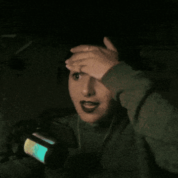 a woman covering her face with her hands while wearing headphones