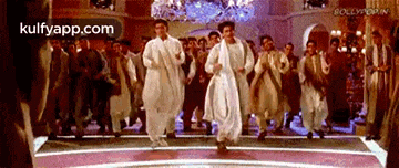 a group of men are dancing on a stage in a room .
