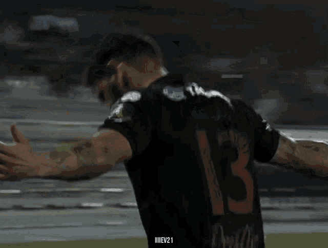 a man wearing a black jersey with the number 13 on it
