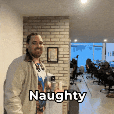 a man standing in a room with the word naughty written on it
