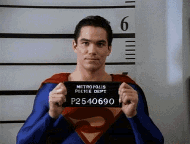 a man in a superman costume holds up a mug shot