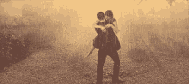 a man is carrying a woman on his shoulders in the rain