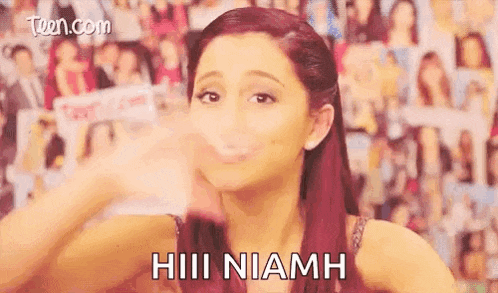 ariana grande is blowing a kiss at the camera in front of a wall of magazines .
