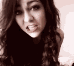 a woman with long hair is making a funny face .