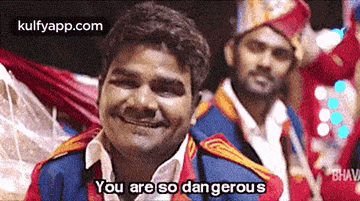 a man is smiling and saying `` you are so dangerous '' in front of two other men .