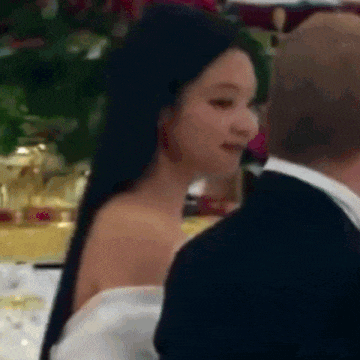a woman in a white dress is standing next to a man in a tuxedo .