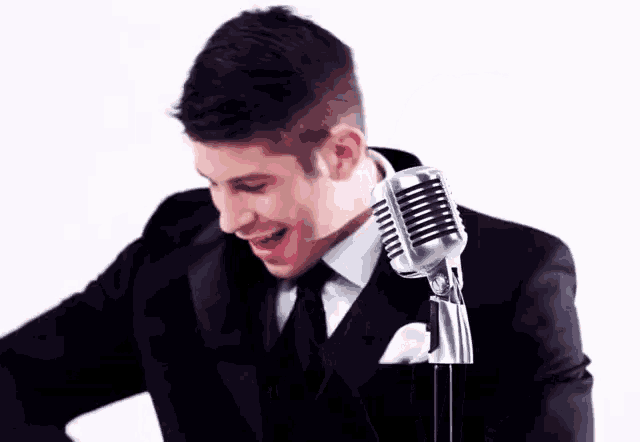 a man in a suit and tie is standing in front of a microphone